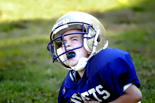 child football athlete crying in uniform after being injured