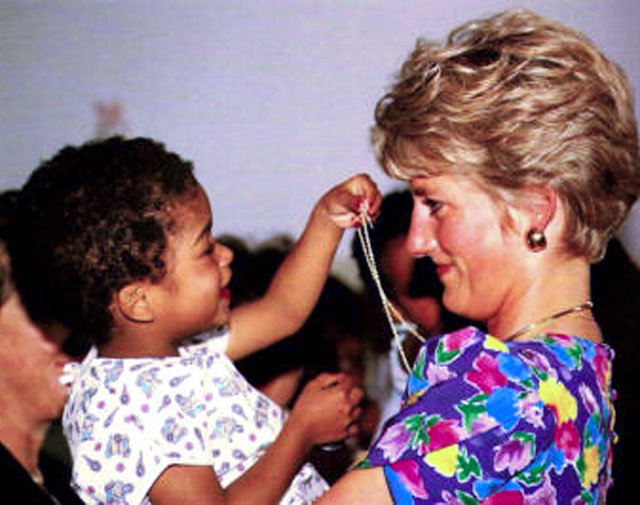 Princess Diana, the first high profile celebrity to be photographed touching a person infected with the HIV virus holds a Brazilian baby with the disease.