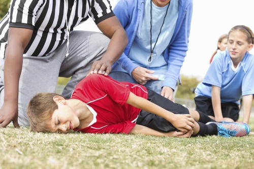 Child with knee injury during soccer game