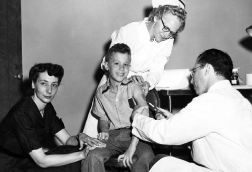 Peter Salk recieving the Salk Polio Vaccine from his father Jonas with the support of his mother