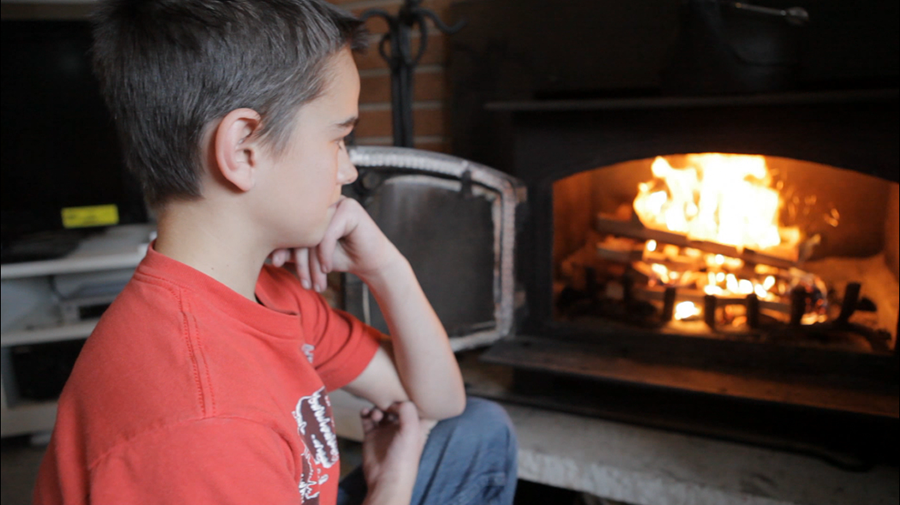 Boy watching wood stove